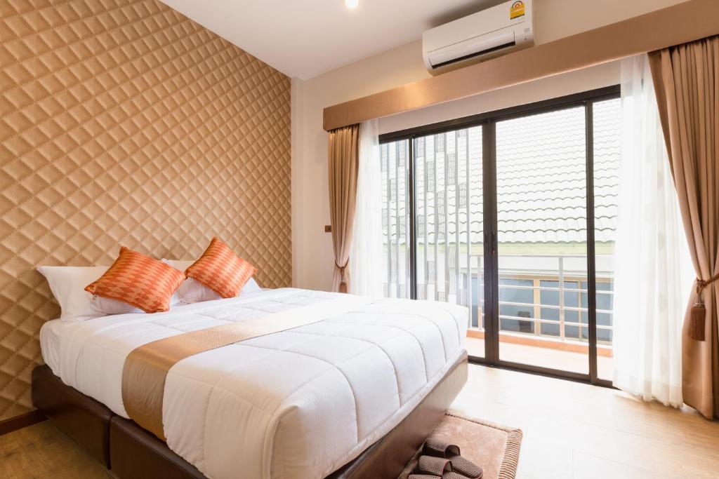 清莱777食宿酒店的一间卧室设有一张大床和一个大窗户