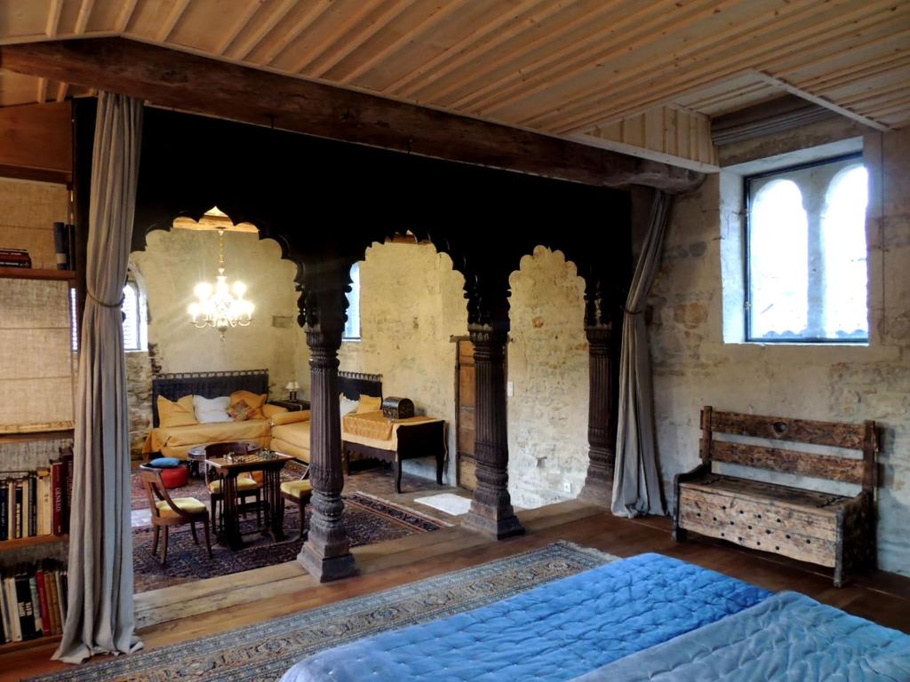 克卢尼Maison Romane 1136的一间卧室设有一张床和一间客厅。