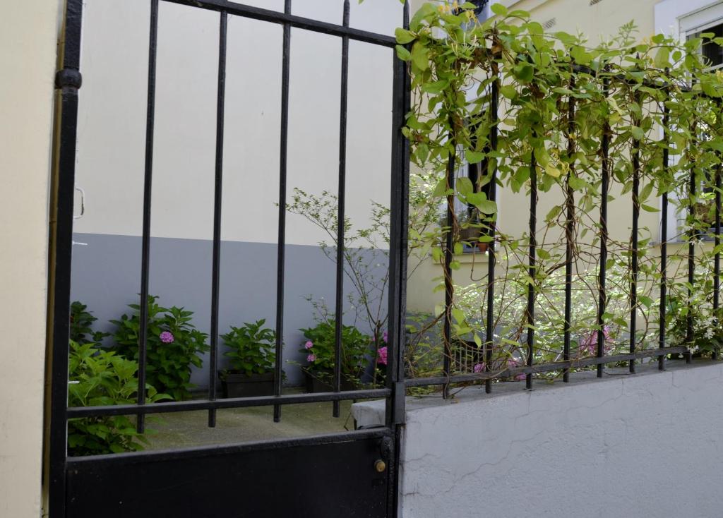 巴黎第五庭院住宿加早餐旅馆的阳台上的黑色门,鲜花盛开
