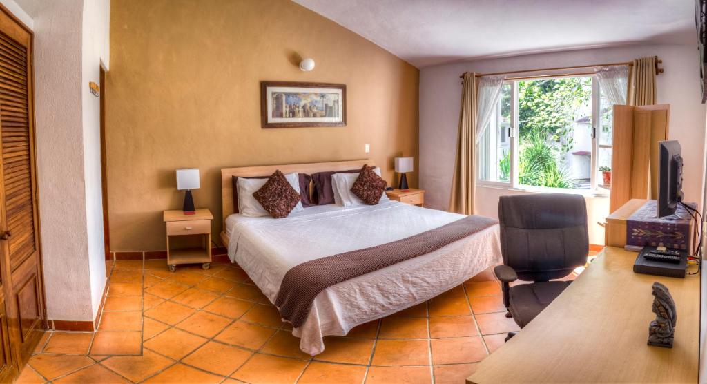 普拉亚卡门卡萨米特索罗旅馆的一间卧室配有一张床、一台电视和一个窗口
