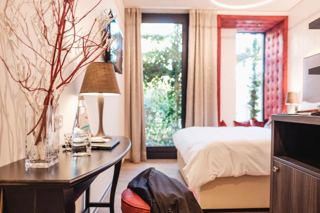 Fürholzen艾瑞克斯酒店的酒店客房配有一张床和一张带台灯的书桌