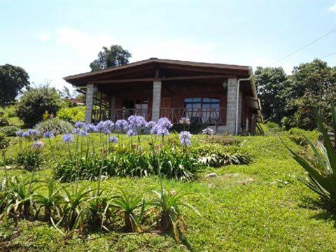 图里亚尔瓦Finca Y Granja Loma Bonita的前面有鲜花的小房子