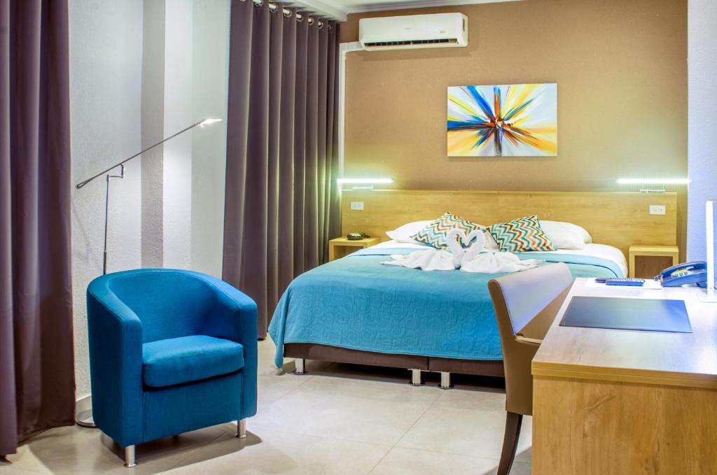 帕拉马里博Q精品酒店的酒店客房,配有一张床和一张蓝色椅子