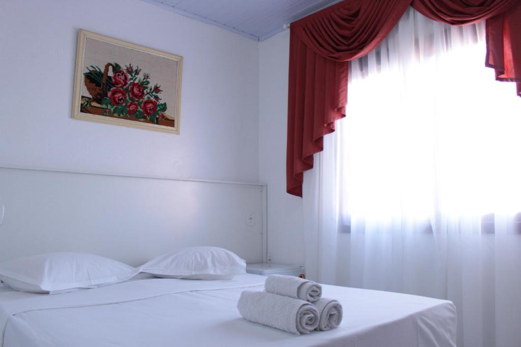 本图贡萨尔维斯唐若昂旅馆的一间卧室设有两张带白色床单的床和窗户。