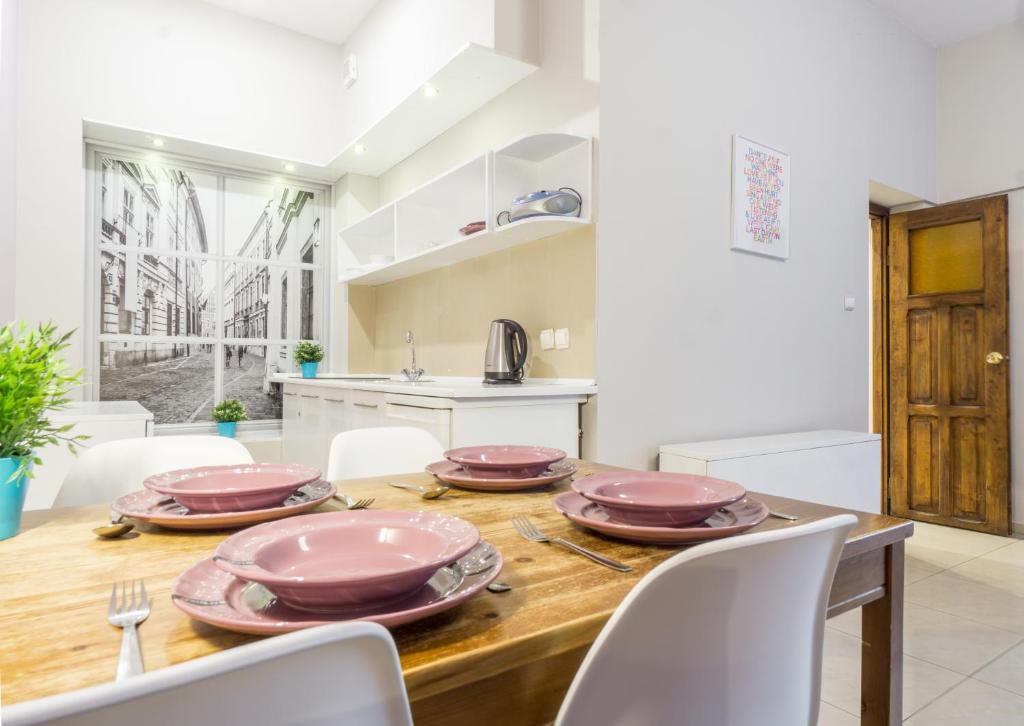 克拉科夫埃迪拉公寓酒店的厨房以及带木桌和椅子的用餐室。