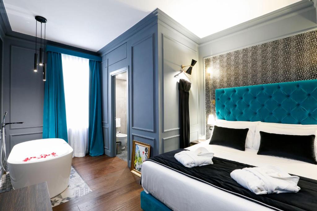 罗马圣B精品STB酒店的一间卧室配有一张大床和蓝色床头板