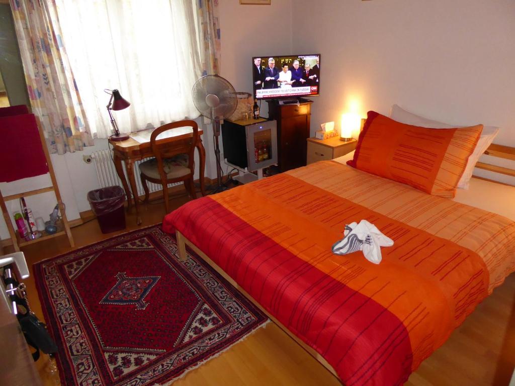 穆滕茨帕佩尔韦格-2号住宿加早餐酒店的一间卧室配有一张带红毯的床和一台电视