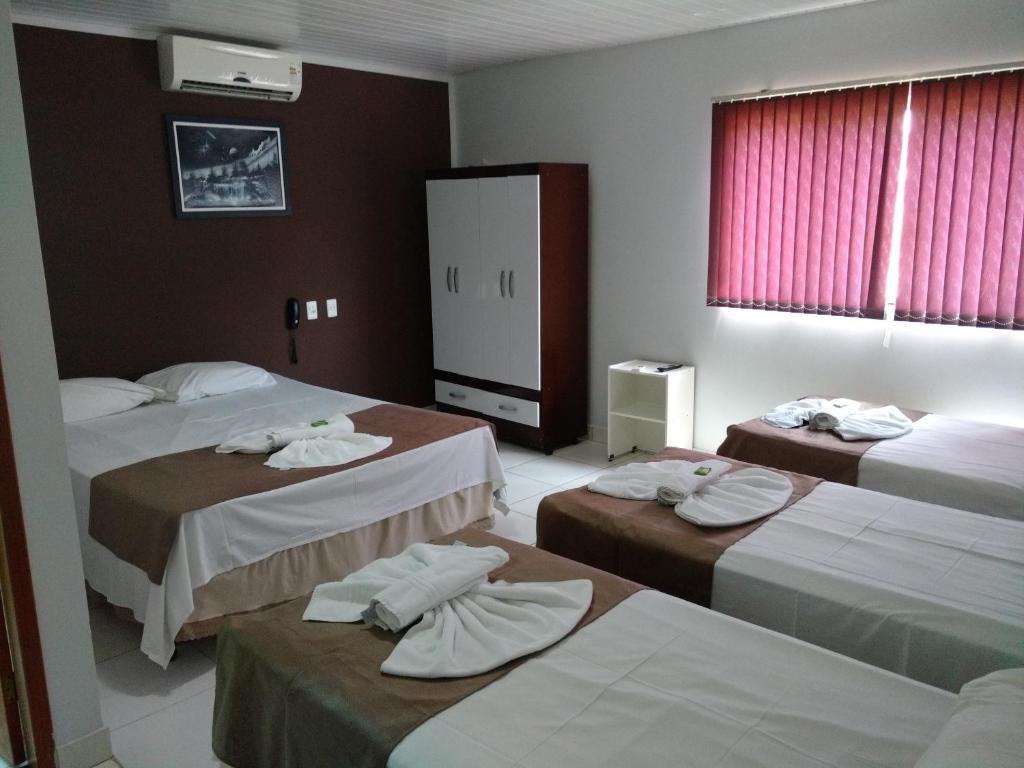 戈亚尼亚Euro Plaza Hotel - Próximo ao Aeroporto de Goiânia, Santa Genoveva的酒店客房,配有三张床和毛巾
