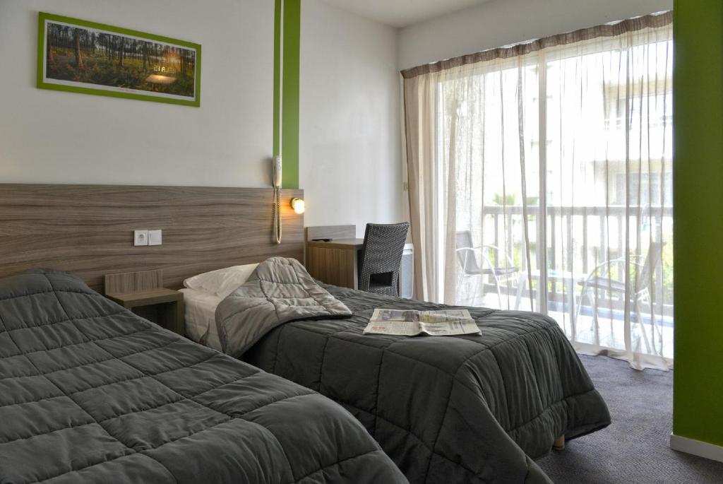 达克斯乐瑞莱斯达克斯酒店的酒店客房设有两张床和窗户。