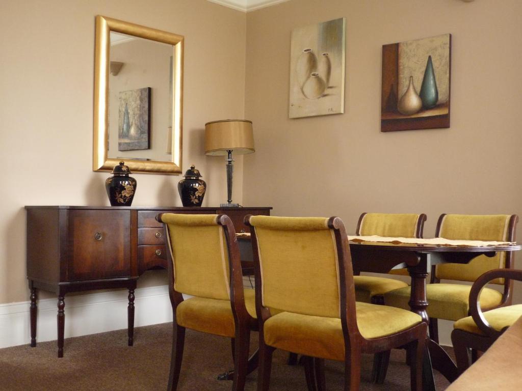 切尔滕纳姆帕拉贡服务式公寓的配有桌椅和镜子的客房