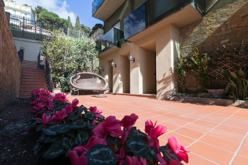 阿拉西奥Residence Sole Mare Alaxi Hotels的房子前面的一束粉红色的花