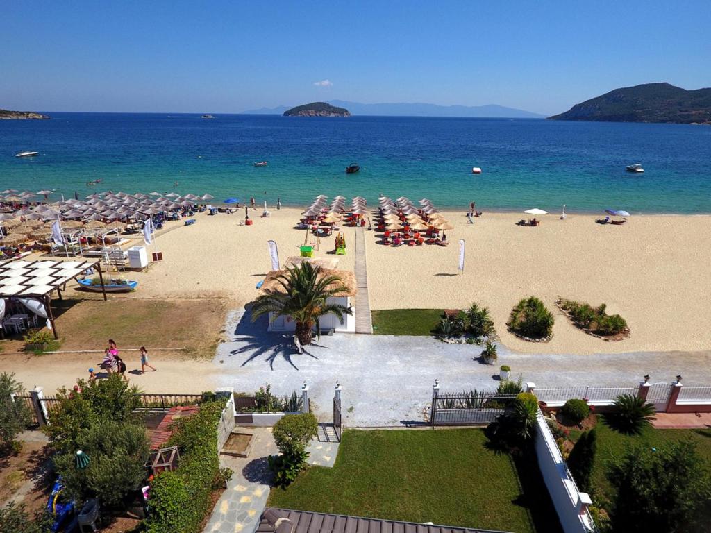 伊拉克里萨Villa Mediterrane Hotel的海滩上有人和遮阳伞海滩