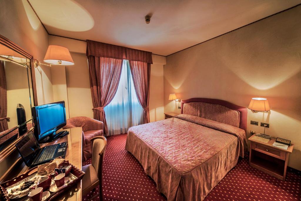 蒙特瓦尔基瓦尔达诺酒店的酒店客房配有一张床和一张带电脑的书桌