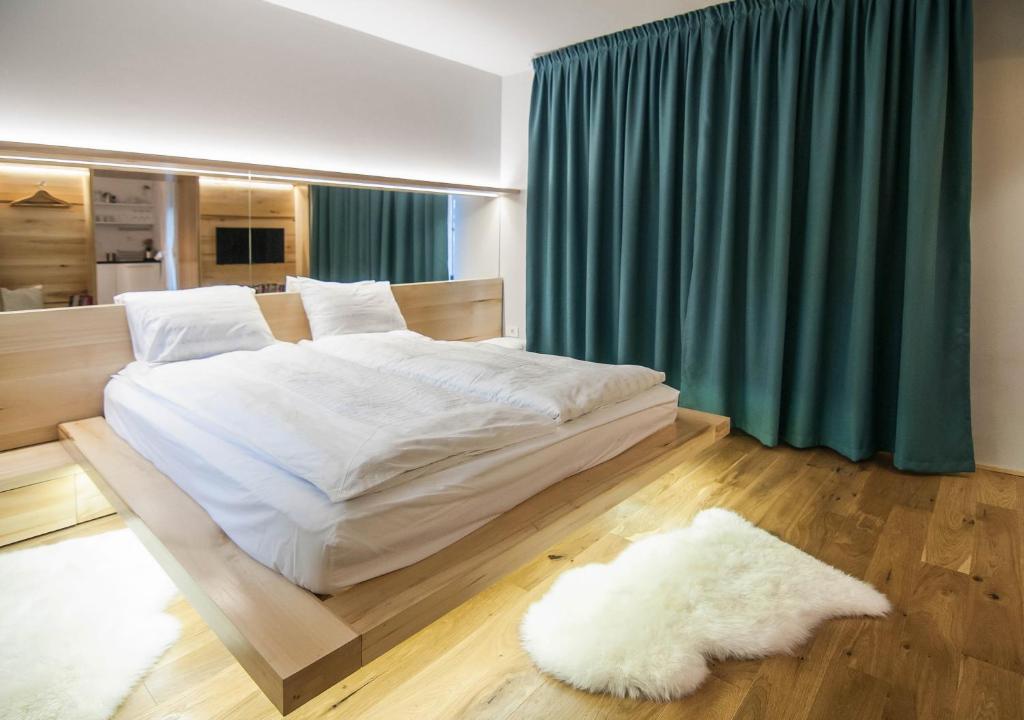 蒂米什瓦拉Garden House的卧室配有白色大床和绿色窗帘