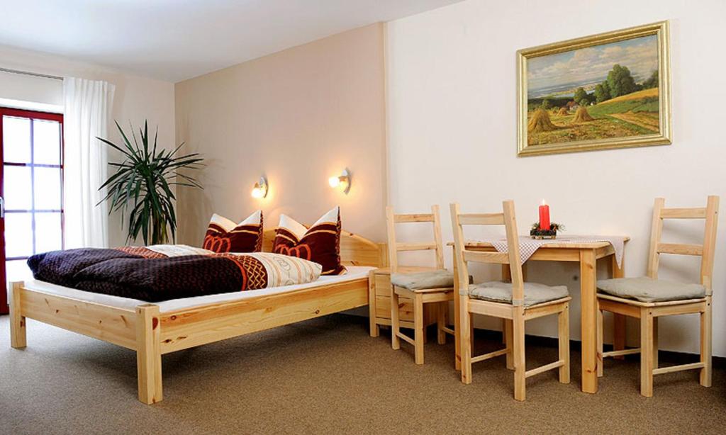 Am DonnerbergFerienwohnungen Altenberg ERZ 060的卧室配有一张床和一张桌子及椅子