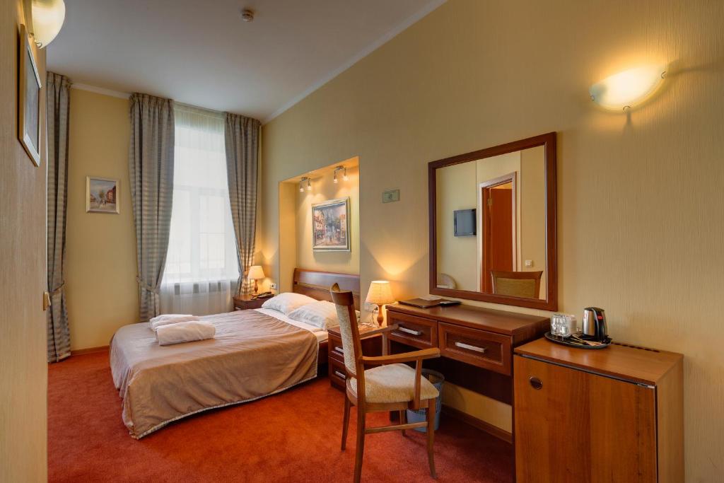 圣彼得堡Solo Isaac Square的一间卧室配有一张床、一张书桌和一面镜子