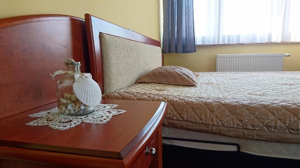 米兹多洛杰Willa Drako的一间卧室配有一张床和一张带花瓶的桌子