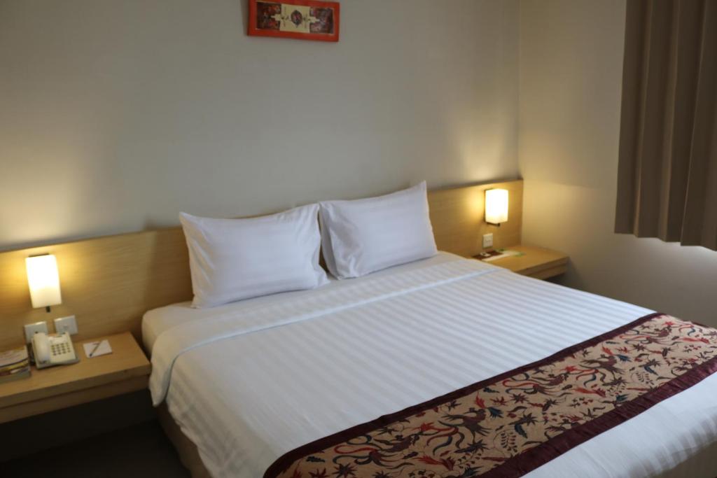 泗水泗水贝奇扎尔酒店的酒店客房设有一张大床和两盏灯