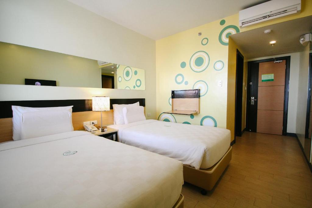 伊洛伊洛伊洛伊洛启航酒店的一间酒店客房,设有两张床和电视
