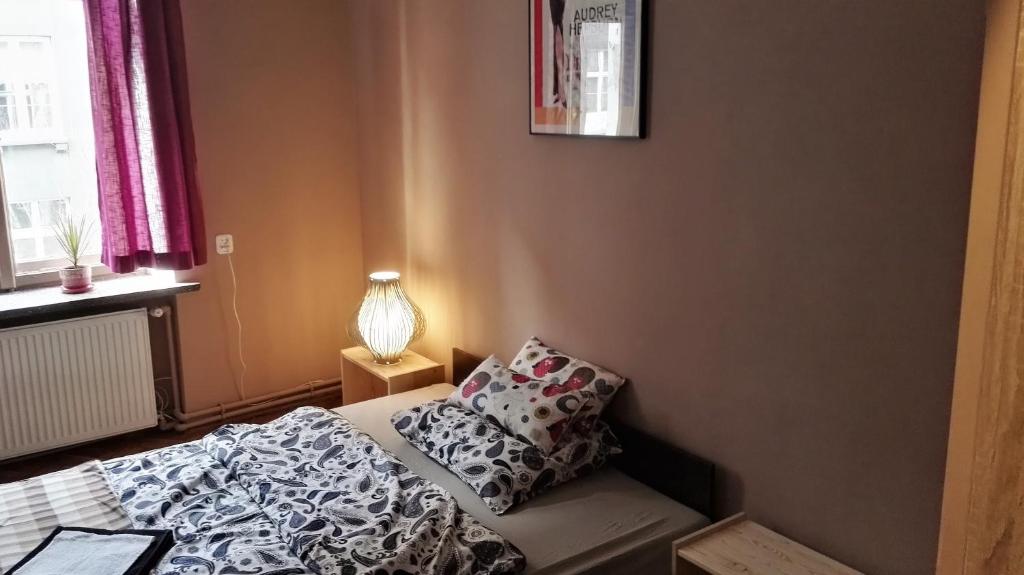 克拉科夫Libroom的一间小卧室,配有床和灯