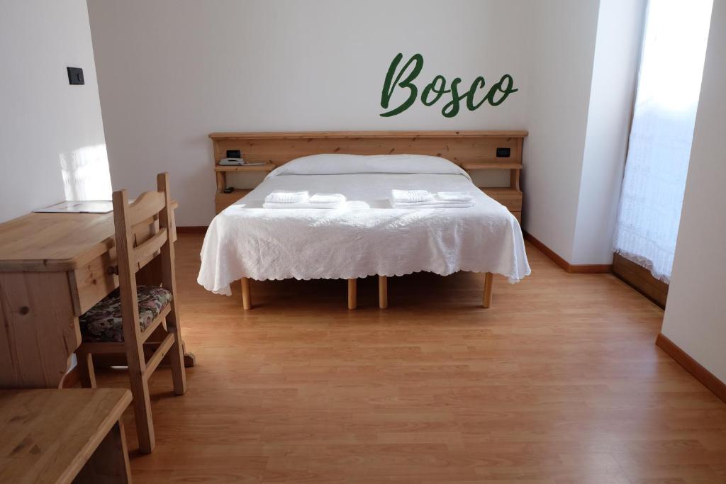 Sant’OrsolaSantorsola Relax Hotel的一间卧室,配有一张床和一张桌子,并标有阅读器