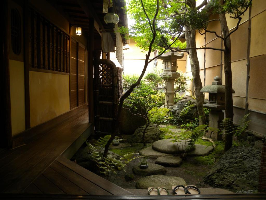 京都金优雅宾馆的一座在建筑前有凉鞋的亚洲花园