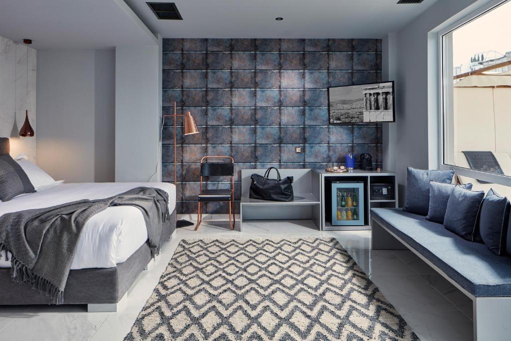 雅典米康海峡18号酒店的一间卧室配有一张床、一把椅子和一张沙发