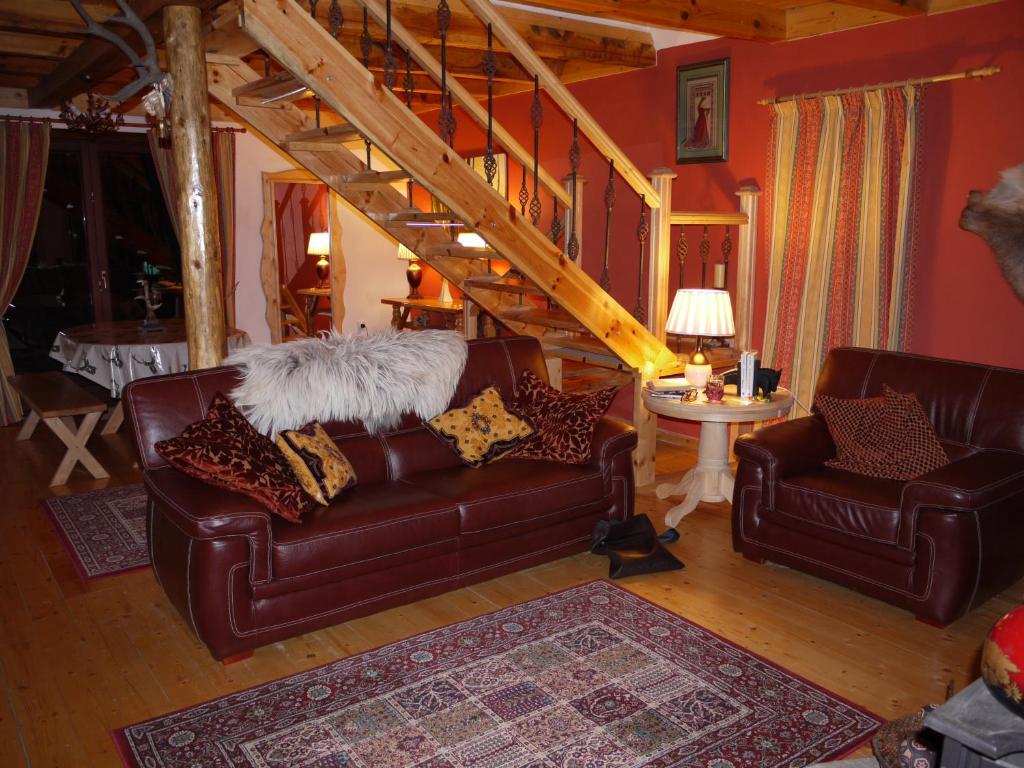 扎布利亚克Zabljak Panoramic View Lodge的客厅设有两张真皮沙发和楼梯