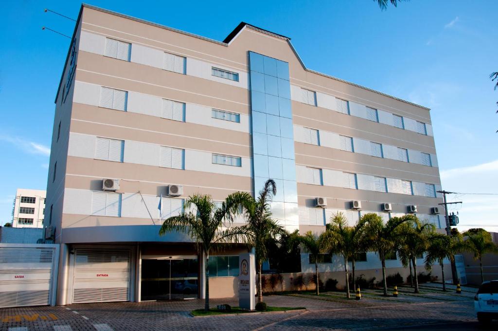 库亚巴莱亚利酒店的一座高大的建筑,前面有棕榈树