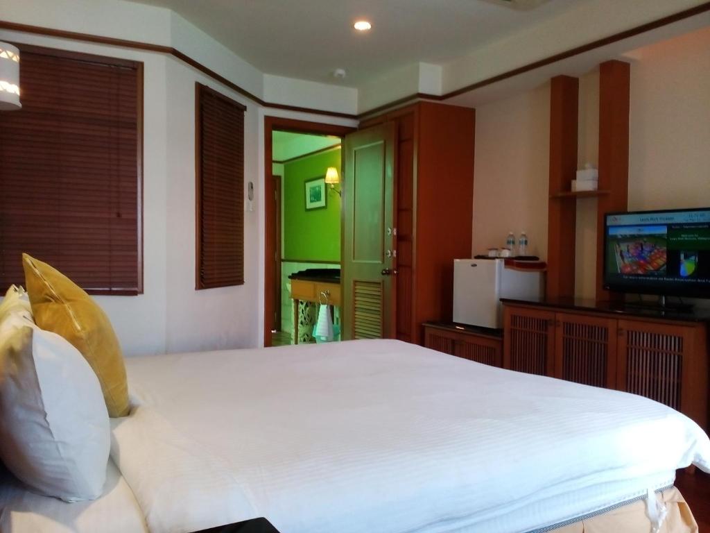 波德申波德申仙境私人度假屋的卧室配有一张白色大床和电视。
