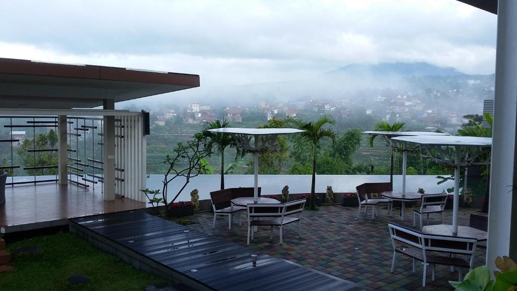 伦邦Moscato Hotel的一个带桌椅的庭院,享有城市美景