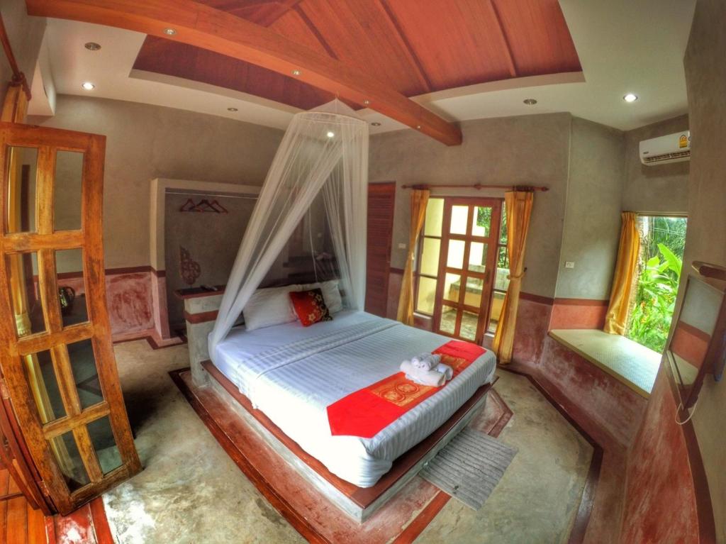 攀牙棕榈山度假村的一间卧室配有一张带蚊帐的床