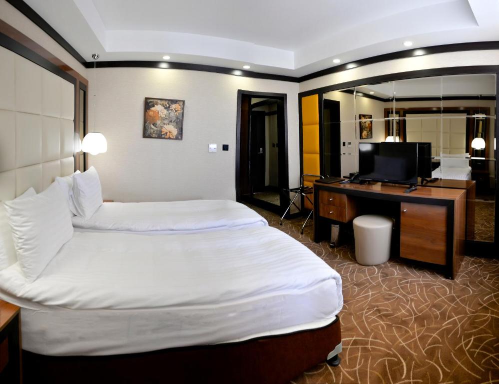 RazgradHotel Cartoon Razgrad的酒店客房配有一张床、一张书桌和一台电视。