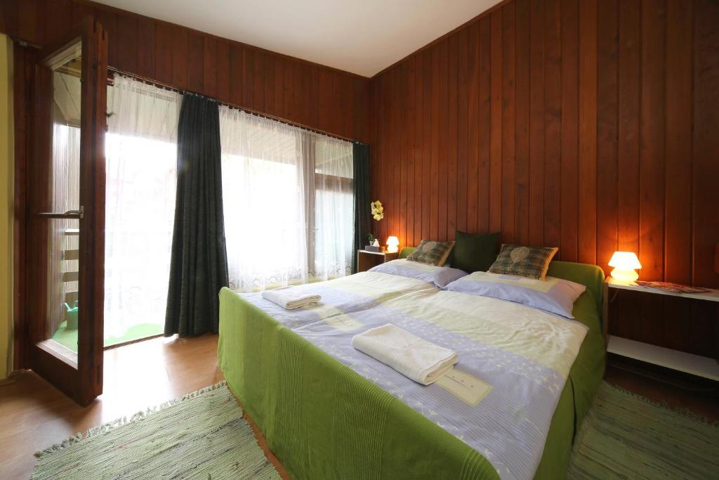 巴拉通雷勒Hotel Melis的一间卧室设有一张带窗户的大型绿色床