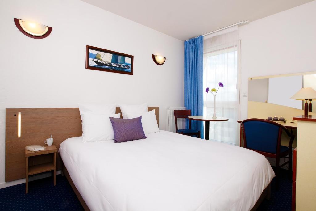 雷恩Appart'City Classic Rennes Beauregard的酒店客房设有一张白色大床和一张桌子。