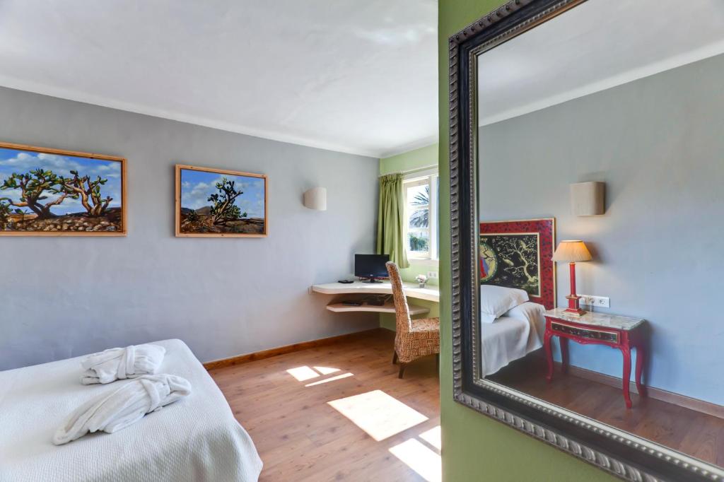 亚伊萨卡萨德希拉里奥酒店的一张床铺和一张书桌,镜子