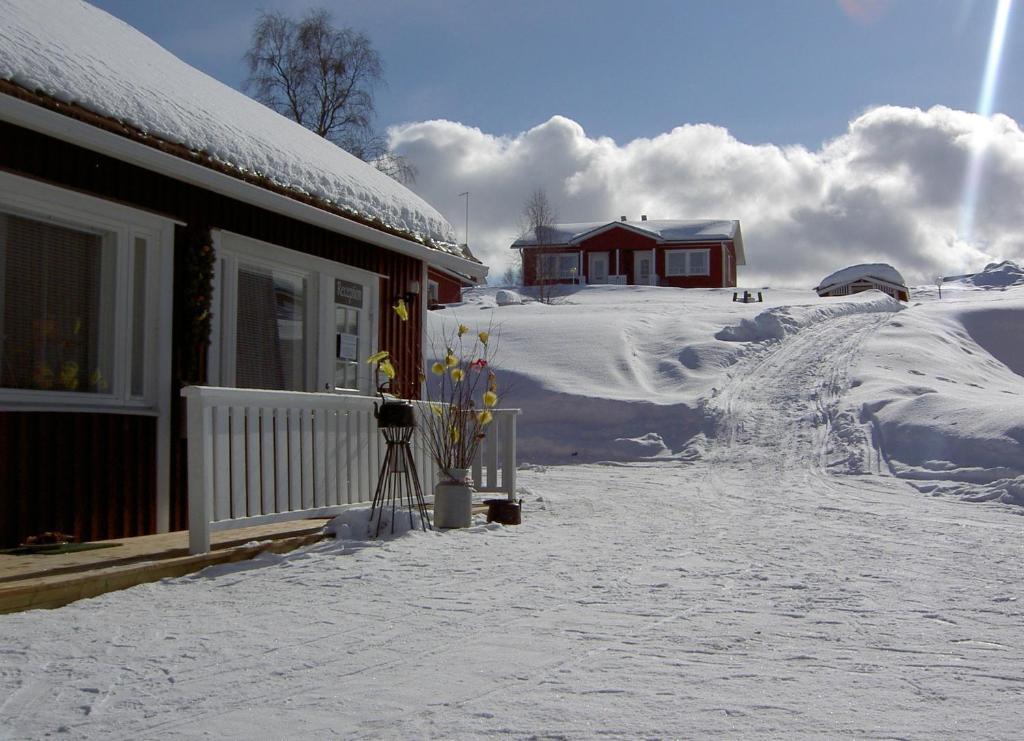 穆奥尼奥佩客内小屋公寓的一堆积雪的房子旁边一个积雪覆盖的院子