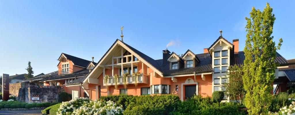 波彭豪森兰道思霍夫瓦瑟库佩酒店的一座大型橙色房子,屋顶黑色