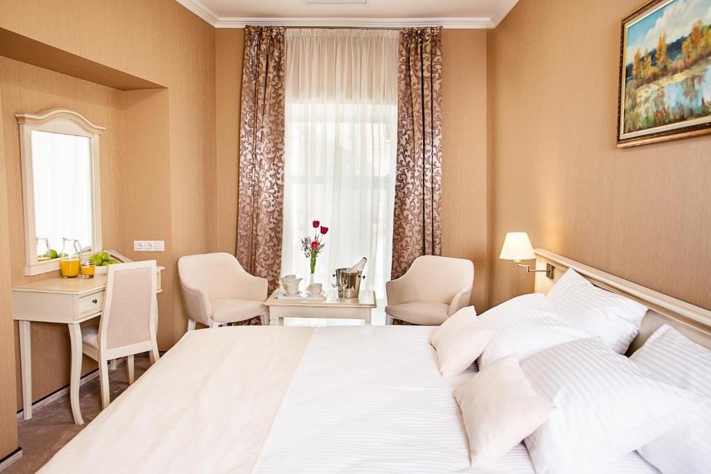 哈尔科夫Pletnevskiy Inn的卧室配有白色的床、书桌和窗户。