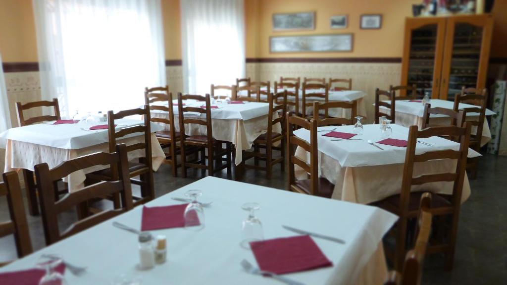 比亚雷亚尔拉玛西亚旅馆兼餐厅的一间用餐室,配有白色的桌椅和红色的餐巾