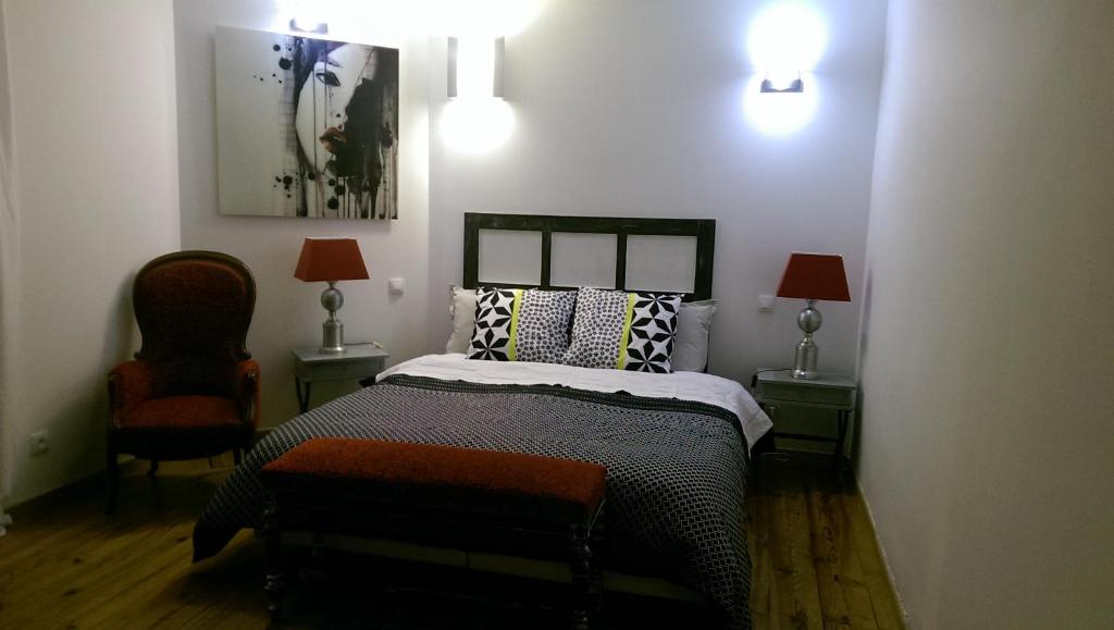 Saint-Vincent-de-Paul伯格罗斯酒店的一间卧室配有一张床、两盏灯和一把椅子