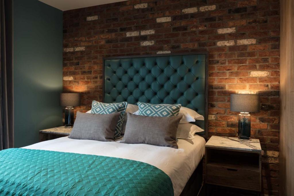 贝克斯希尔The Driftwood Bexhill的一间卧室设有一张带砖墙的大床