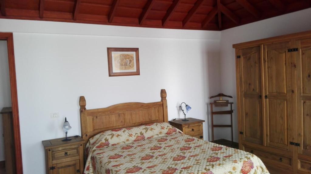 丰卡连特德拉帕尔马Casa Clara的一间卧室配有一张床和两个木制橱柜。