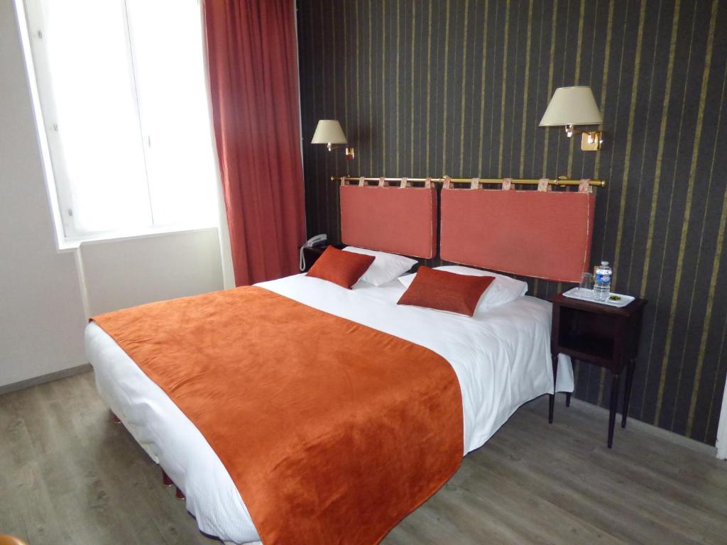 马耶讷之家大酒店的酒店客房设有一张带橙色毯子的大床