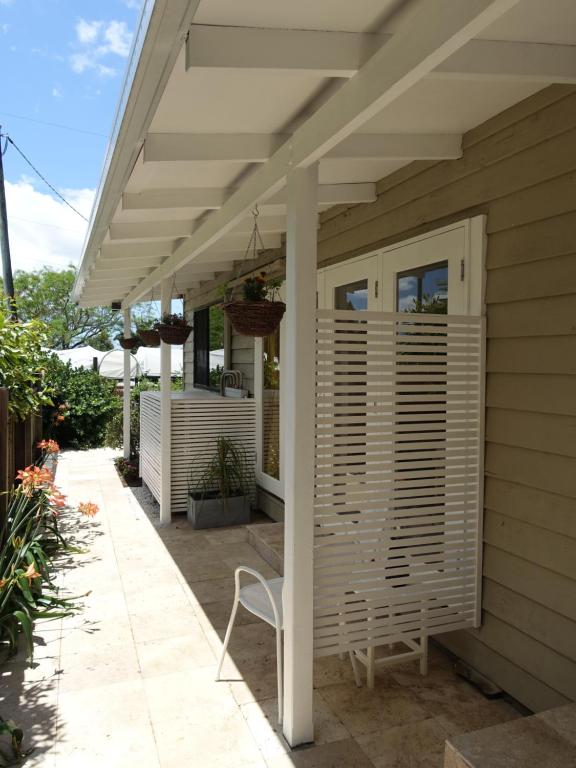 Palmwoods温斯顿科塔基住宿加早餐旅馆的庭院配有白色凉棚和椅子