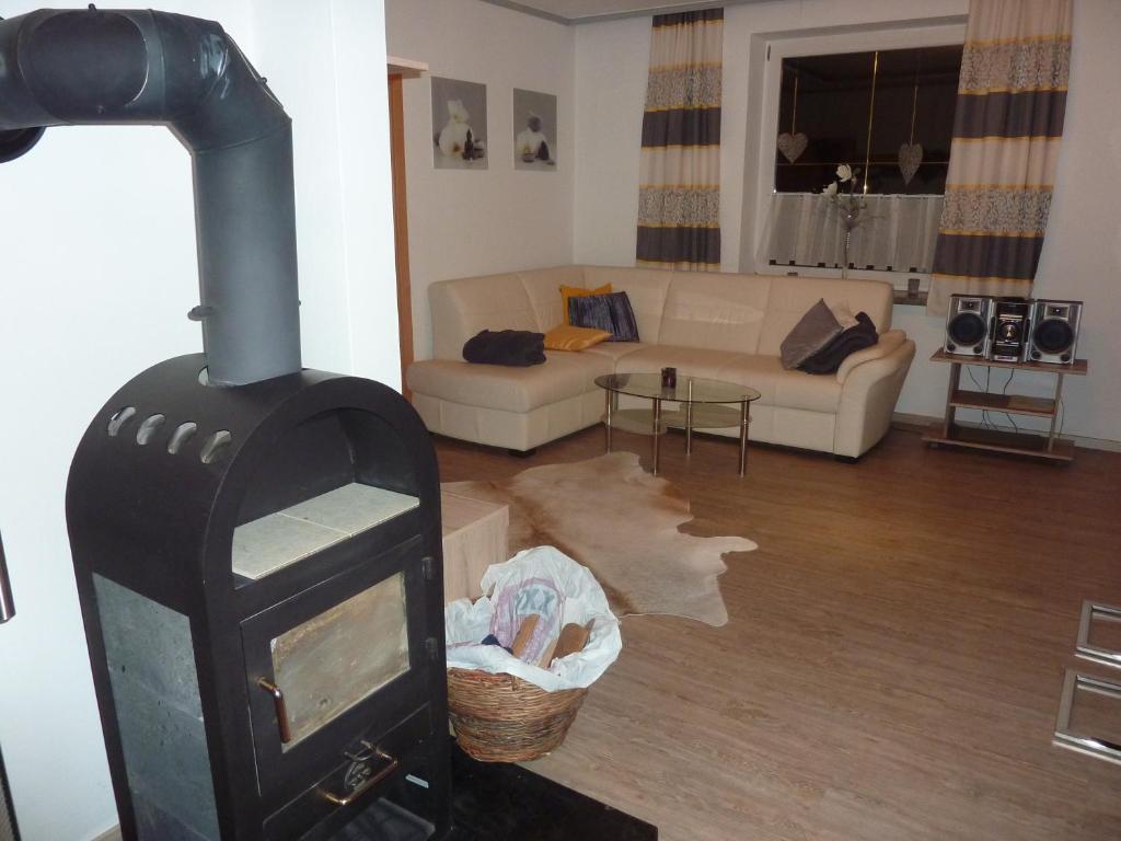 霍赫菲尔岑Ferienwohnung mit Blick auf die Buchensteinwand的客厅设有燃木炉