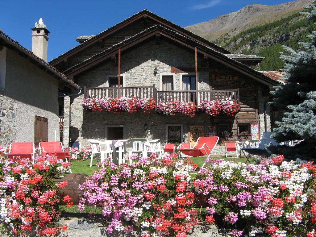 科涅Hotel Petit Giles的带阳台的房屋,配有红色椅子和鲜花