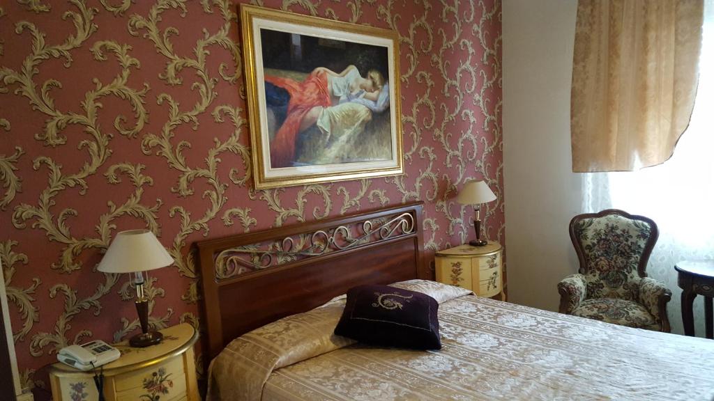 亚历山德里亚Hotel Royal的卧室配有一张床,墙上挂着一幅画
