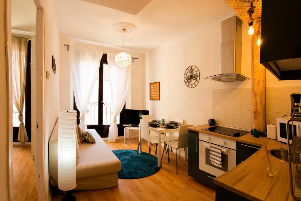 哈罗Apartamento Santo Tomas 23 Izq的厨房以及带沙发和桌子的客厅。
