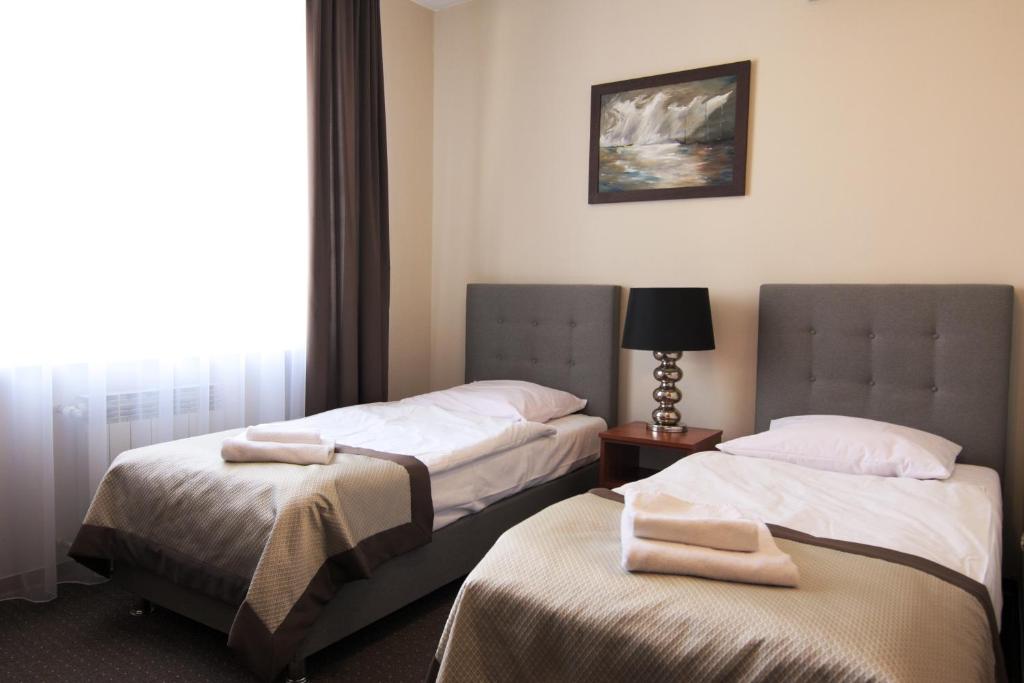 华沙姆鲁福卡会议中心公寓式酒店的配有窗户的酒店客房内的两张床
